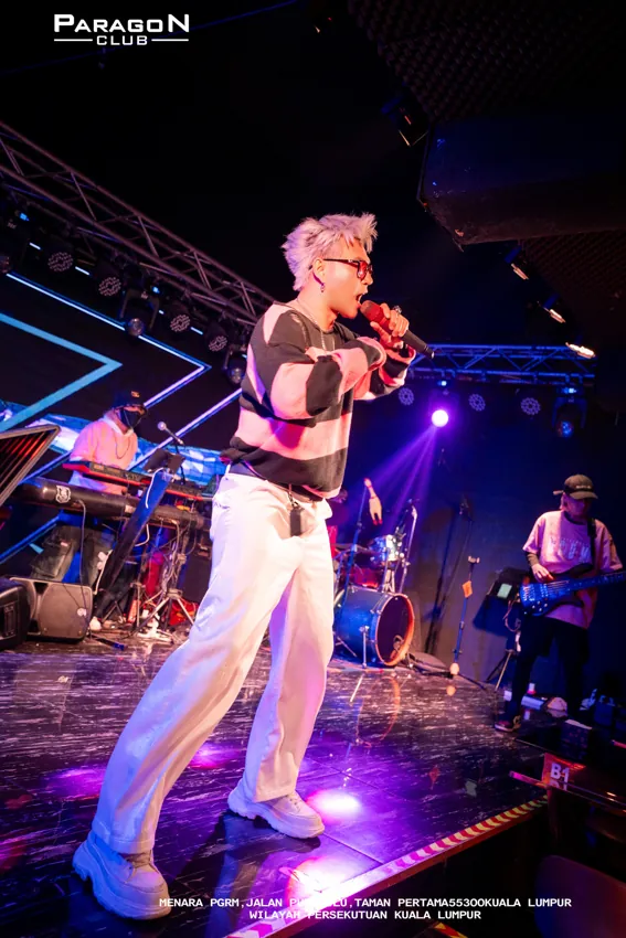 Saxophonist in white trousers on the illuminated runway at Paragon Club, Cheras