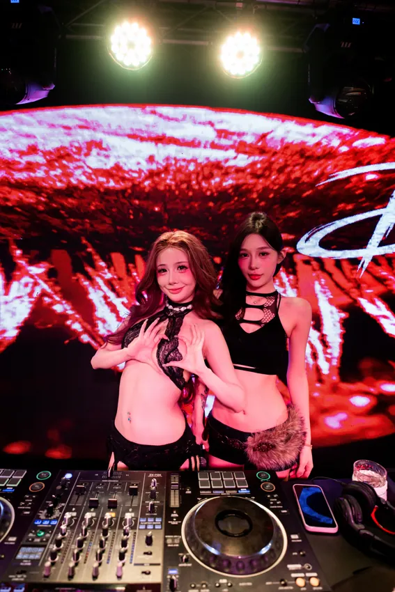 Two DJs behind the decks against a red LED backdrop at Paragon Club, Cheras